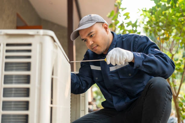 Illustrative technician examining a residential outdoor air conditioning system